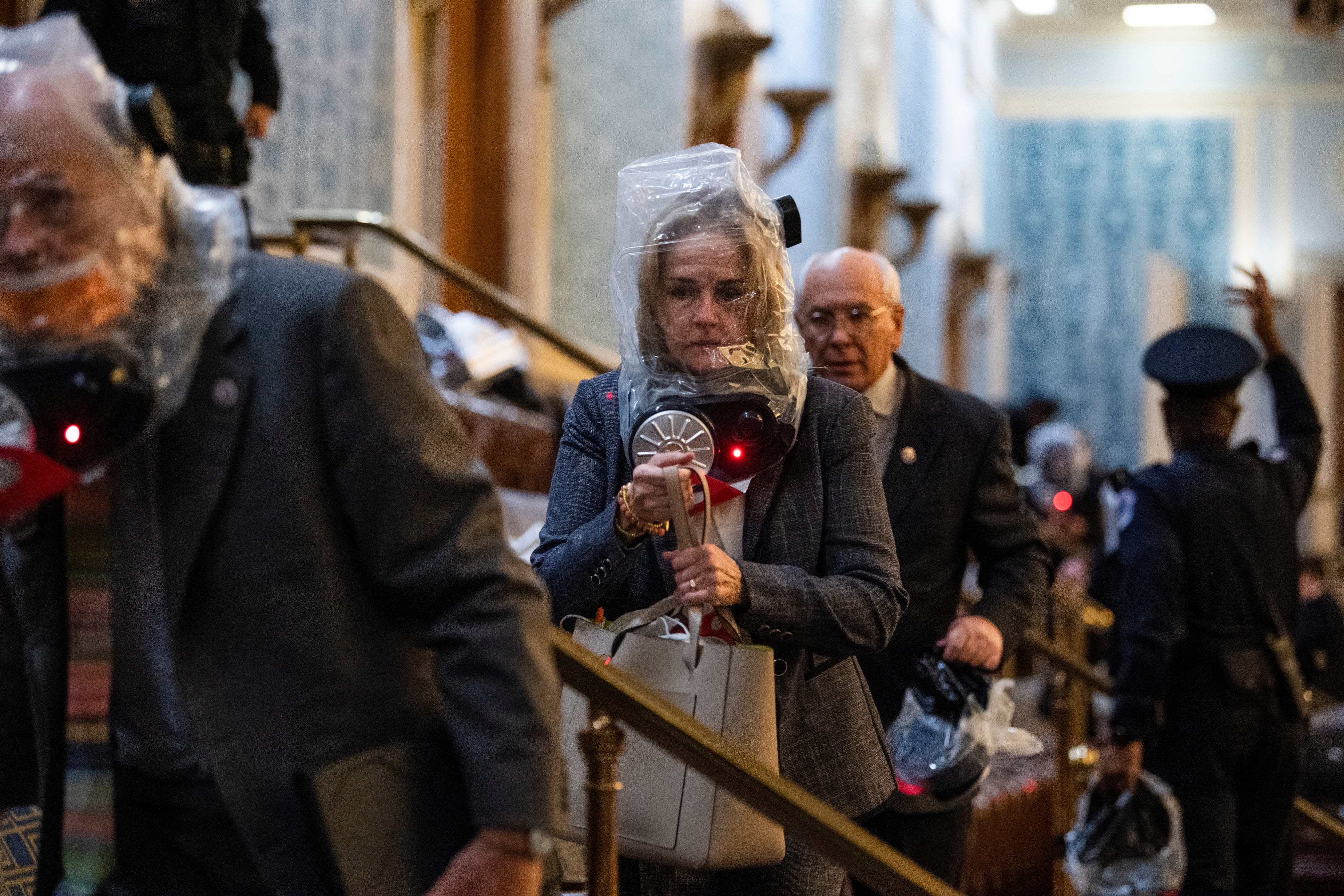 Rep. Madeleine Dean, D-Pa., and other members take cover as protesters disrupt the joint session of Congress to certify the Electoral College vote on Wednesday, January 6, 2021.