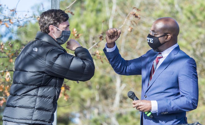 Jon Ossoff, left, and Raphael Warnock, who are U.S. Senate candidates from Georgia, celebrate their victories on Wednesday, Jan. 6, 2021, in Atlanta.