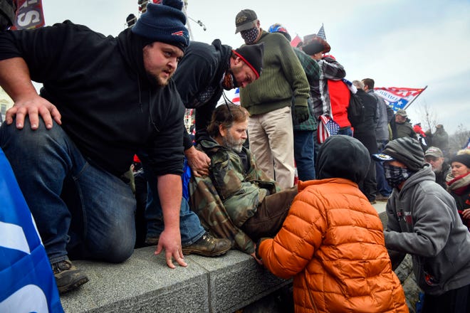 Protesters climb over walls heading to inauguration stand on the west front at the United States Capitol as the U.S. Congress meets to formally ratify Joe Biden as the winner of the 2020 Presidential election on Jan. 6.