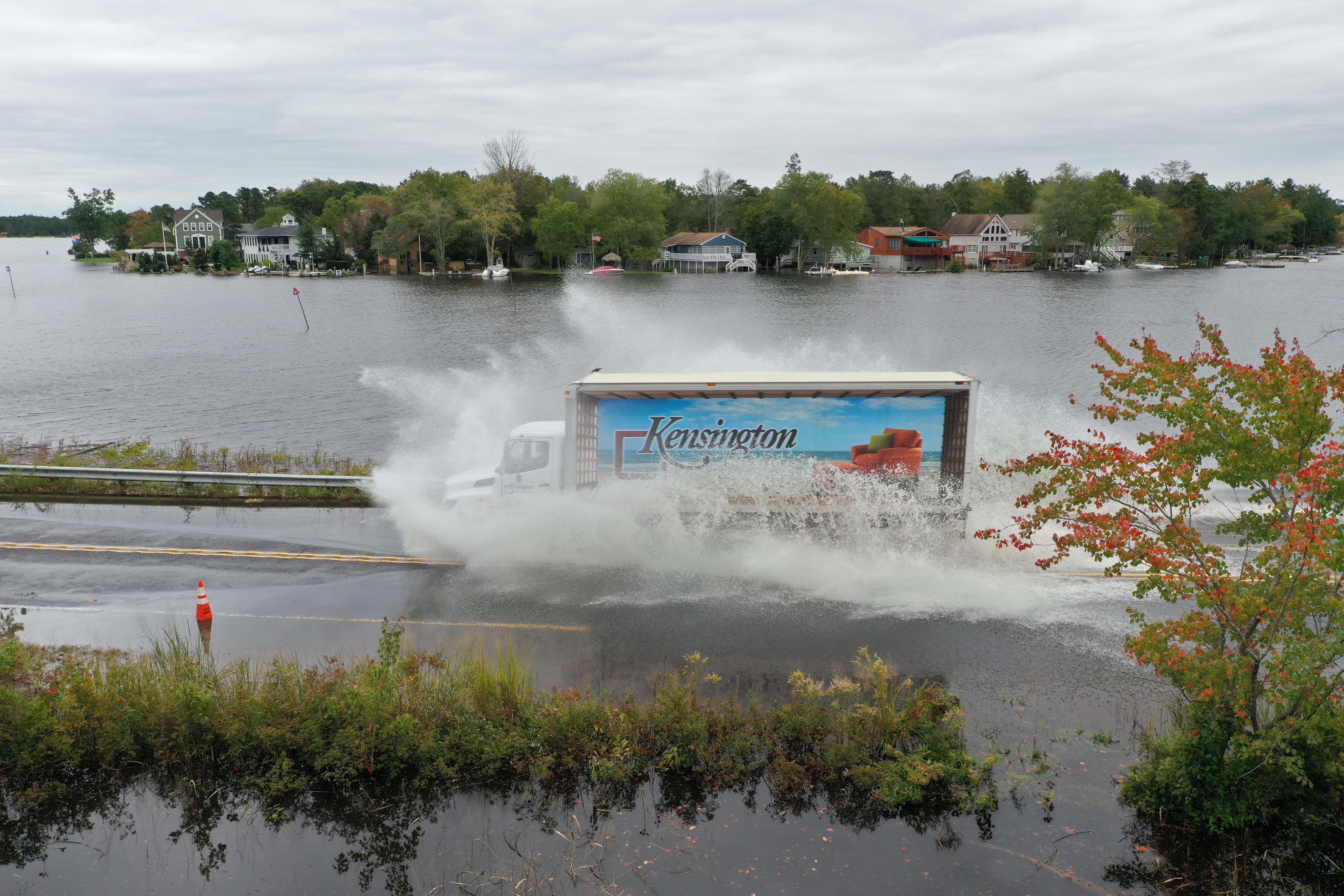 A truck navigates a flooded road during a king tide in October 2019 along the Mullica River in Southeastern New Jersey. NOAA records show coastal flooding is occurring more often as sea levels rise, especially during lunar high tides in the fall. [Photos by Life on the Edge Drones, provided by Jacques Cousteau National Estuarine Research Reserve]