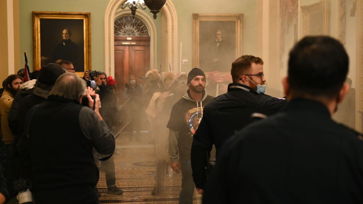 Supporters of US President Donald Trump enter the US Capitol as smoke fills the corridor on January 6, 2021, in Washington, DC. There are no reports of tear gas being used at the Capitol.