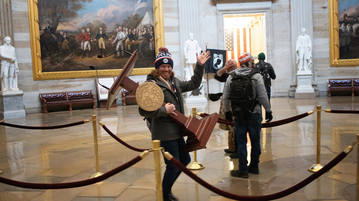 A pro-Trump protester, who has been identified as Adam Johnson of Parrish, carries the lectern of U.S. Speaker of the House Nancy Pelosi through the Rotunda of the U.S. Capitol Building after a pro-Trump mob stormed the building on Wednesday.