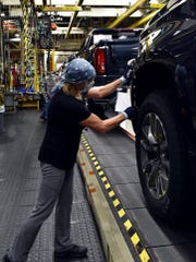 A worker wears a face mask while building GM’s full-sized pickups at Fort Wayne Assembly plant in Indiana. Jan. 7, 2021.
