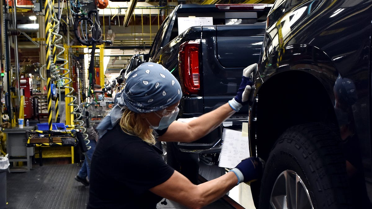 A worker wears a face mask while building GM's full-sized pickups at Fort Wayne Assembly plant in Indiana. Jan. 7, 2021.
