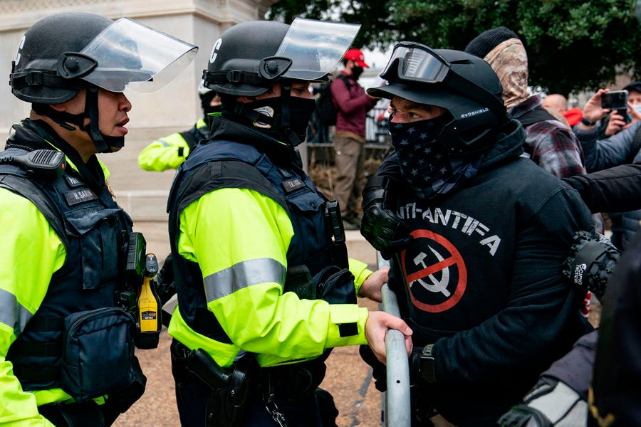 A protester, who claims to be a member of the Proud Boys, confronts police officers as supporters of US President Donald Trump protest outside the US Capitol on January 6, 2021, in Washington, DC.