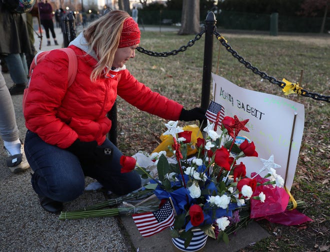 Melody Black, a Minnesota resident, visits a memorial set up Jan. 7 near the U.S. Capitol for Ashli Babbitt, a Donald Trump supporter who was killed by a police officer when she and others stormed the building Jan. 6.