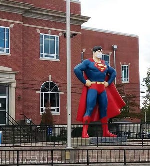 A statue of Superman, complete with COVID-19 mask, stands next to the Massac County Courthouse in Metropolis.