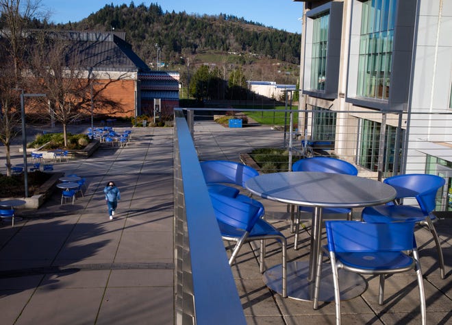 A visiter walks through a deserted Lane Community College campus as most students continue taking classes online.