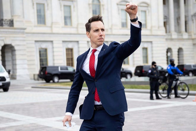 Sen. Josh Hawley (R-Mo.) gestures toward a crowd of supporters of President Donald Trump gathered outside the U.S. Capitol to protest the certification of President-elect Joe Biden's electoral college victory Jan. 6 at the U.S. Capitol in Washington, DC. Some demonstrators later breached security and stormed the Capitol.