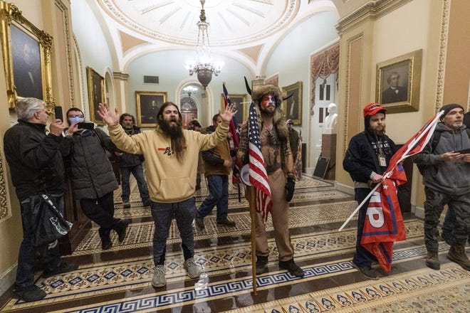 In this Wednesday, Jan. 6, 2021 file photo supporters of President Donald Trump are confronted by U.S. Capitol Police officers outside the Senate Chamber inside the Capitol in Washington.