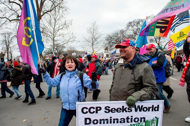 "Super Fun Happy America's" Susan Ianni of Natick, and Mark Shahady march through the streets of Washington, D.C., as they make their way to the Capitol Building, Jan. 6, 2020. President Donald Trump's supporters stormed a session of Congress during certification of President-elect Joe Biden's election win, triggering unprecedented chaos and violence at the heart of American democracy.