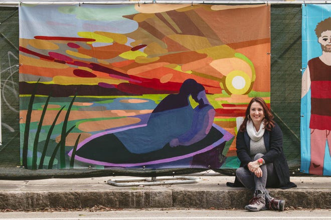 Artist Dana Richardson with her canvas on the construction fencing on Drayton near Bolton Street. Richardson’s work is a part of the Starland Mural Project Fence Art.