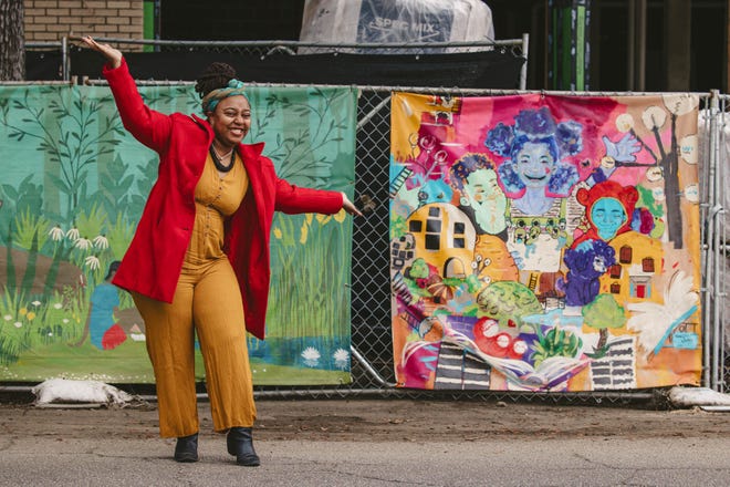 Artist Nae'Keisha Jones with her canvas on the construction fencing on Bull near 31st street. Naekeisha’s work is a part of the Starland Mural Project Fence Art.