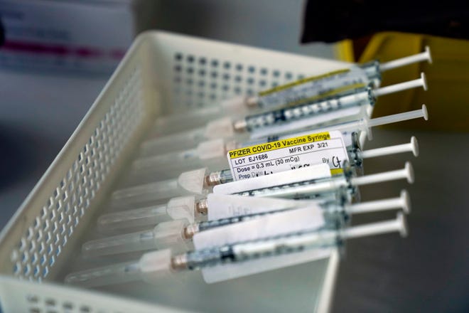 Syringes containing the Pfizer-BioNTech COVID-19 vaccine sit in a tray.