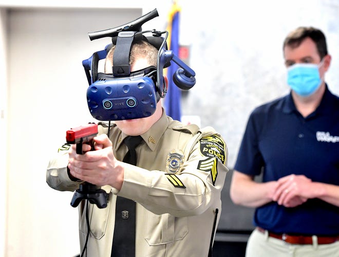 Northern York County Regional Police Department Sgt. Cody Becker, left, is watched by Ethan Moeller, vice president of WRAP Reality, while Becker used a virtual reality law enforcement simulator during training at the department Monday, Jan. 11, 2021. Bill Kalina photo