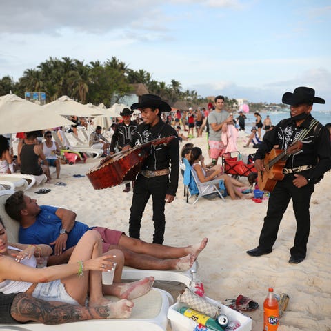 Roving musicians "Los Compas" approach a group of 