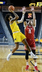 Michigan forward Isaiah Livers (2) shoots over Wisconsin forward Micah Potter (11) in the first half.