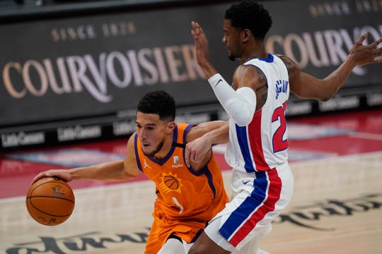 Phoenix Suns guard Devin Booker (1) drives on Detroit Pistons forward Josh Jackson (20) during the first half of an NBA basketball game, Friday, Jan. 8, 2021, in Detroit. (AP Photo/Carlos Osorio).