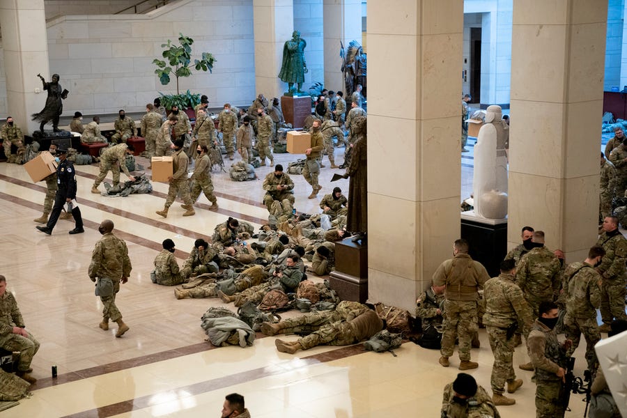 Members of the National Guard rest in the Visitor Center of the U.S. Capitol on Wednesday.