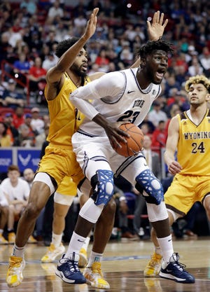 Utah State's Neemias Queta (23) pulls down a rebound as Wyoming's Trevon Taylor, left, defends during the first half of an NCAA college basketball game in the Mountain West Conference men's tournament Friday, March 6, 2020, in Las Vegas. (AP Photo/Isaac Brekken)