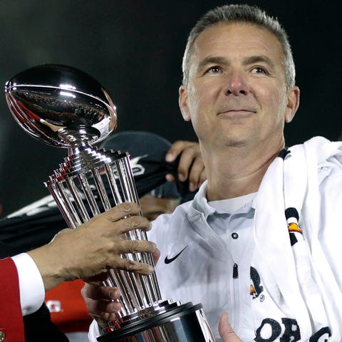 Urban Meyer as Ohio State coach holds the trophy a