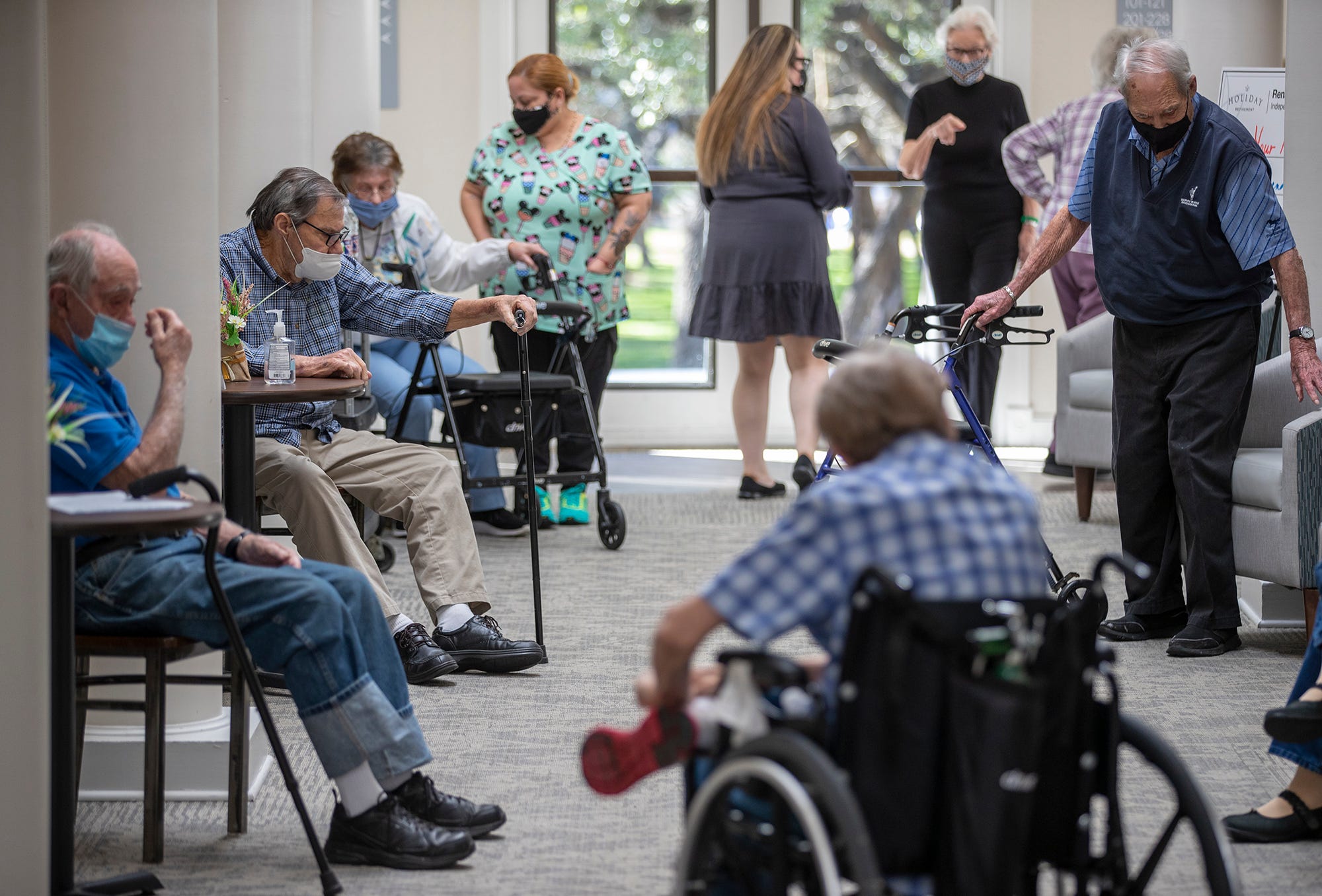 A long line of residents waits to receive the Pfizer-BioNtech COVID-19 vaccine at the Renaissance-Austin senior living facility in north Austin on Friday, January 15, 2021. This facility is among the first long-term care facilities to receive Pfizer-BioNtech COVID-19 vaccines in the Austin area.