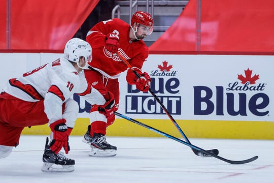 Detroit Red Wings center Dylan Larkin (71) shoots the puck against Carolina Hurricanes during the third period of the season opener at the Little Caesars Arena in Detroit on Thursday, Jan. 14, 2021.
