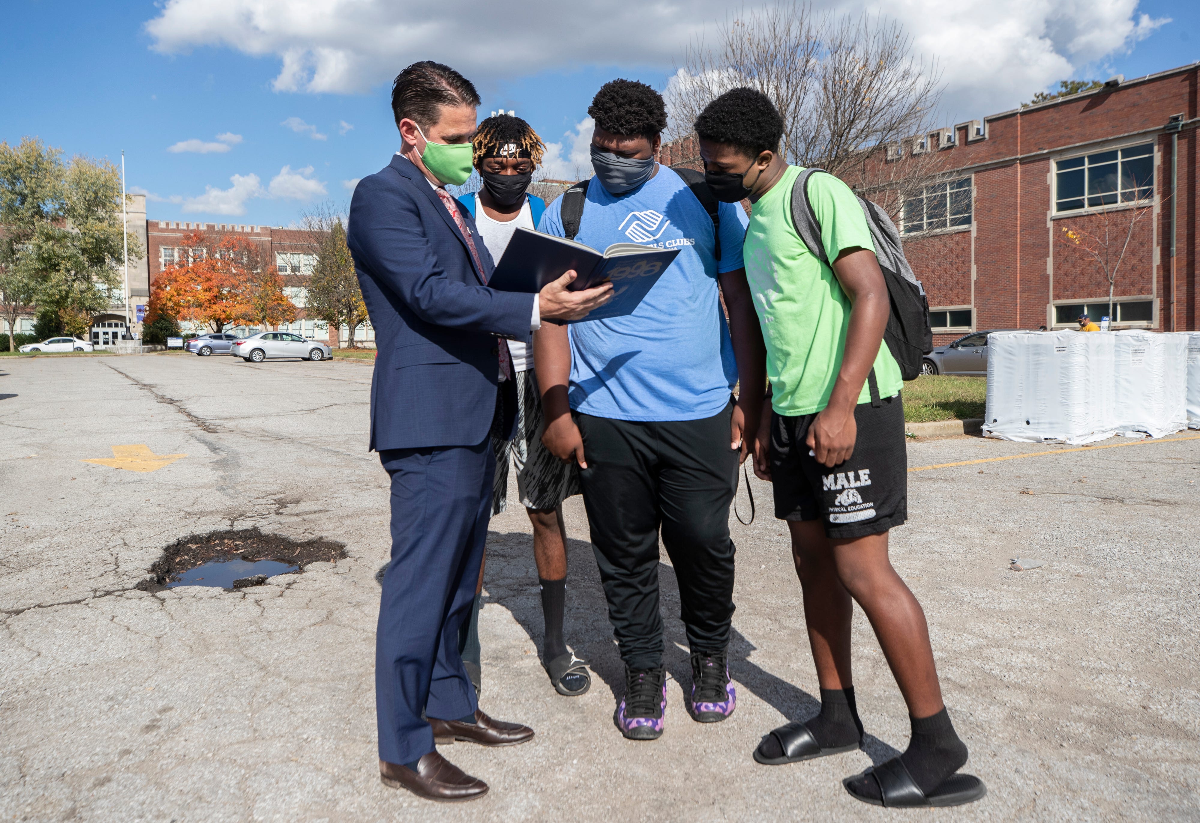 JCPS Superintendent Dr. Marty Pollio shows photos from an Academy @ Shawnee yearbook, from the time he taught there, to members of the school's football team. Pollio hopes to once again allow students in west Louisville to attend their neighborhood school. Oct. 22, 2020