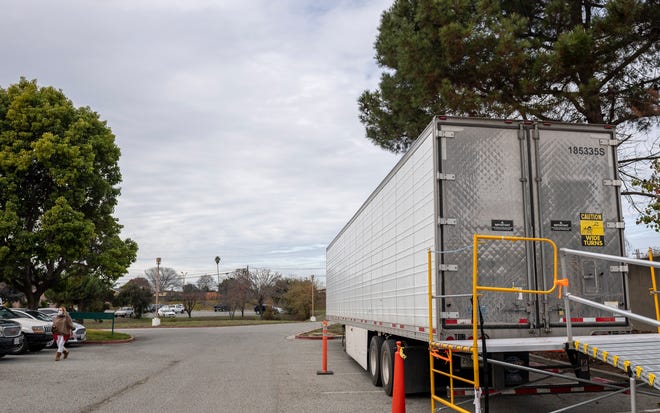 A person walking near a refrigerated trailer parked outside the Coroners office in Monterey County, Salinas, California, on Tuesday, January 12, 2021. 