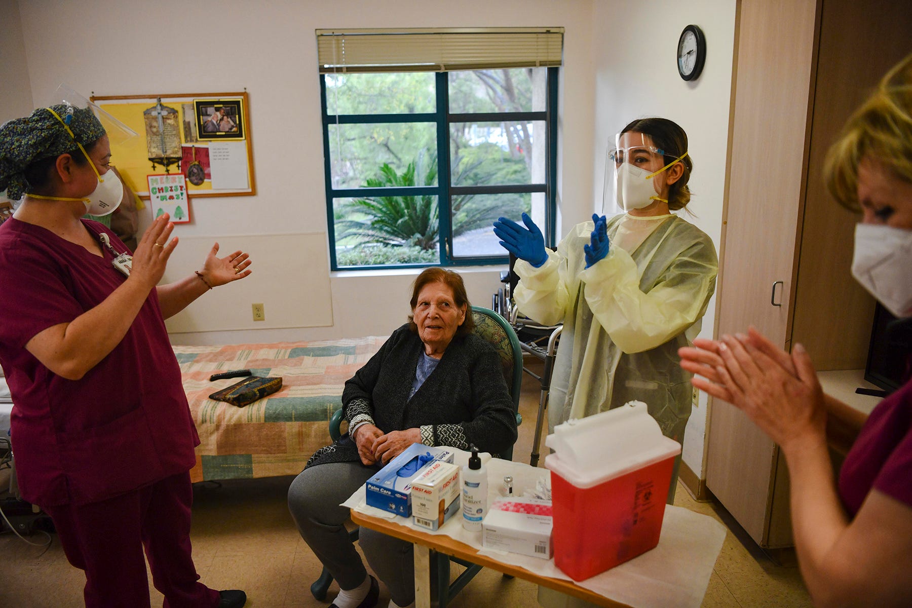 Nurses cheer for resident Tamara Keshishzadeh after she receives Moderna's COVID-19 vaccine.