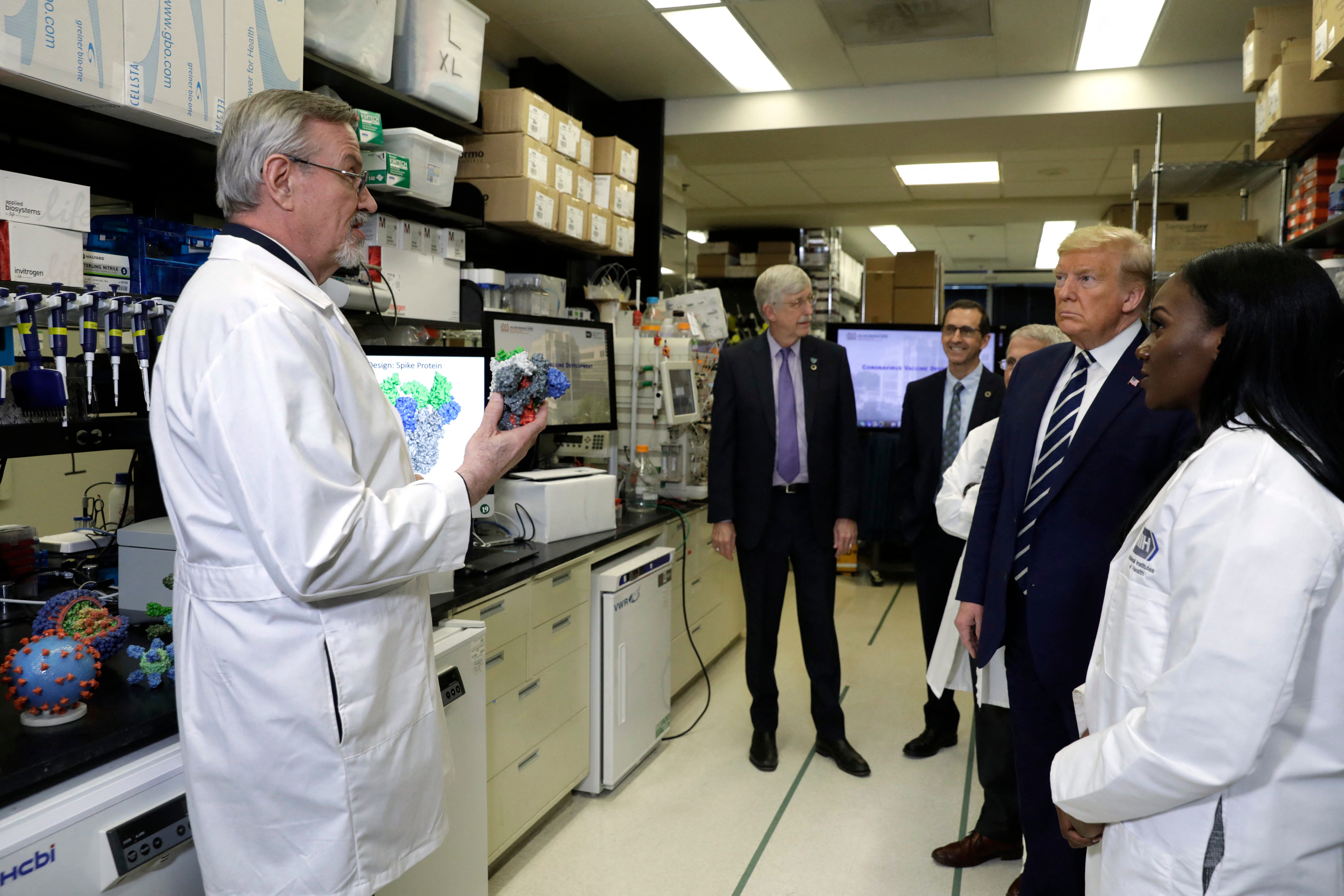 President Donald Trump tours the NIH's Health Vaccine Research Center on March 3, 2020 with Barney Graham, left, and Kizzmekia Corbett, right.
