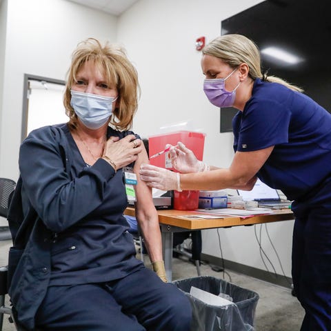 Nursing student Brandi White, right, injects her m