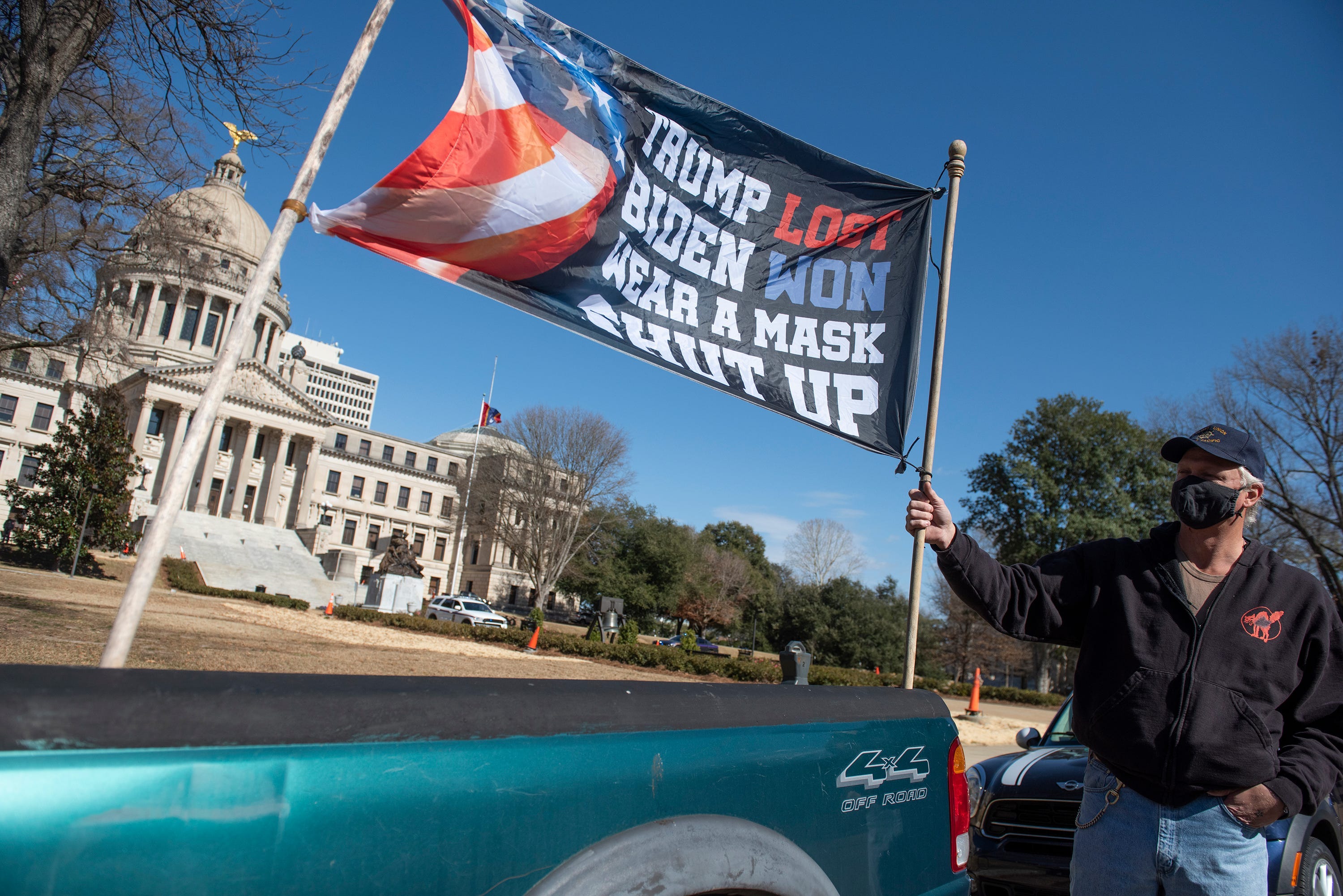 Dale Gibson, of Jackson, Miss., shows off the banner he planned to hold as a counter protester if a pro-Trump rally materialized, Sunday, Jan. 17, 2021, in Jackson. Visibly enhanced security surrounded the Mississippi State Capitol.