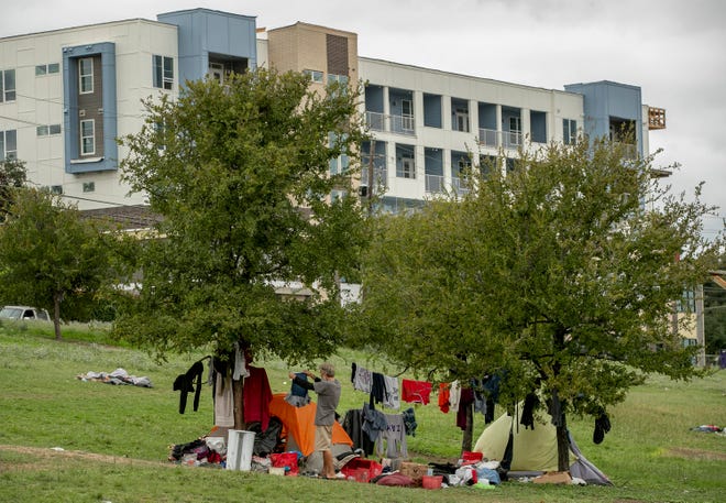 Homeless people camp in the median of East Riverside Drive in Southeast Austin on Sept. 24.  An Austin group says it has collected the required number of petition signatures to bring the city's homeless camping ordinance before voters in May.
