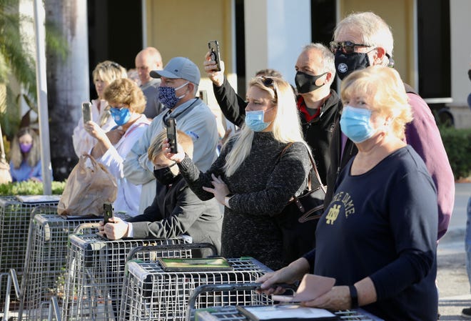A small crowd of people listens on Tuesday, Jan. 19, 2021, as Gov. Ron DeSantis announces that vaccinations against COVID-19 are coming to all 67 Publix Super Markets in Palm Beach County. DeSantis made the announcement outside the Publix at Sea Plum Town Center in Jupiter.