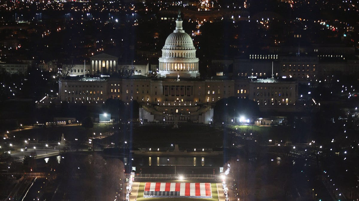 The "Field of Flags" is illuminated on the National Mall as the US Capitol Building is prepared for the inauguration ceremonies for President-elect Joe Biden and Vice President-elect Kamala Harris on Jan. 18, 2021 in Washington, DC.  Approximately 191,500 US flags will cover part of the National Mall and will represent the American people who are unable to travel to Washington, DC for the inauguration. 