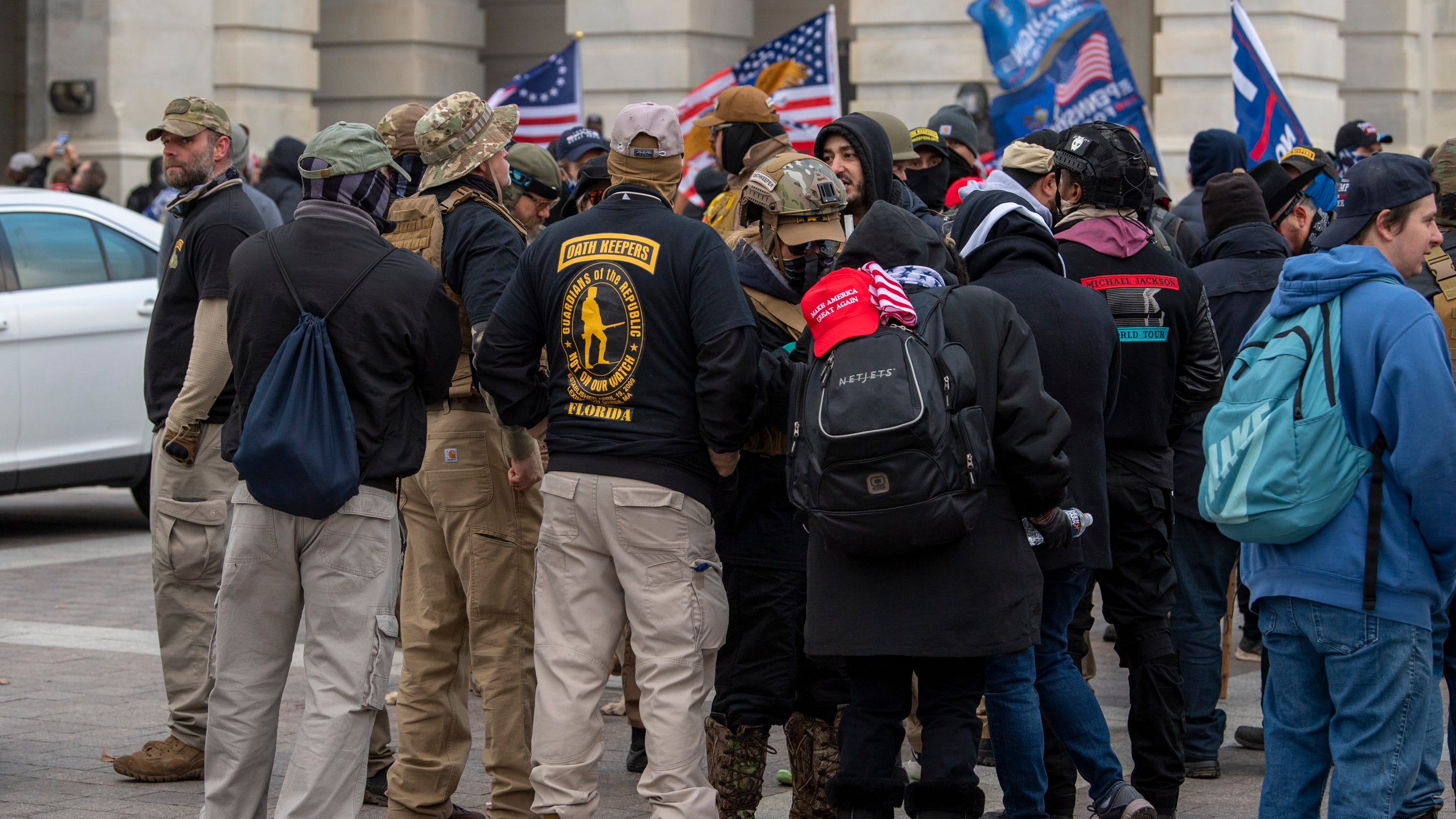A group of men, some of whom are wearing "Oath Keepers" insignia, gathers as rioters storm the U.S. Capitol in Washington on Jan. 6.