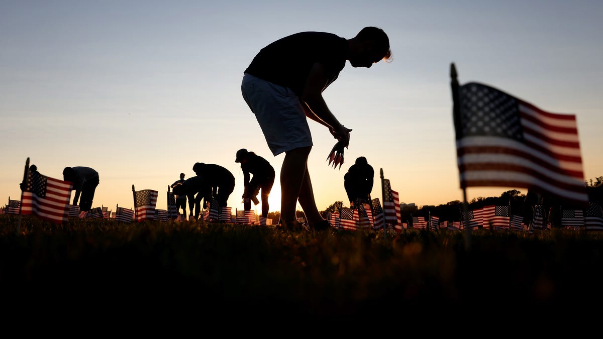 Volunteers with the COVID Memorial Project install 20,000 American flags on the National Mall as the United States crosses the 200,000 lives lost in the COVID-19 pandemic September 20, 2020 in Washington, DC.