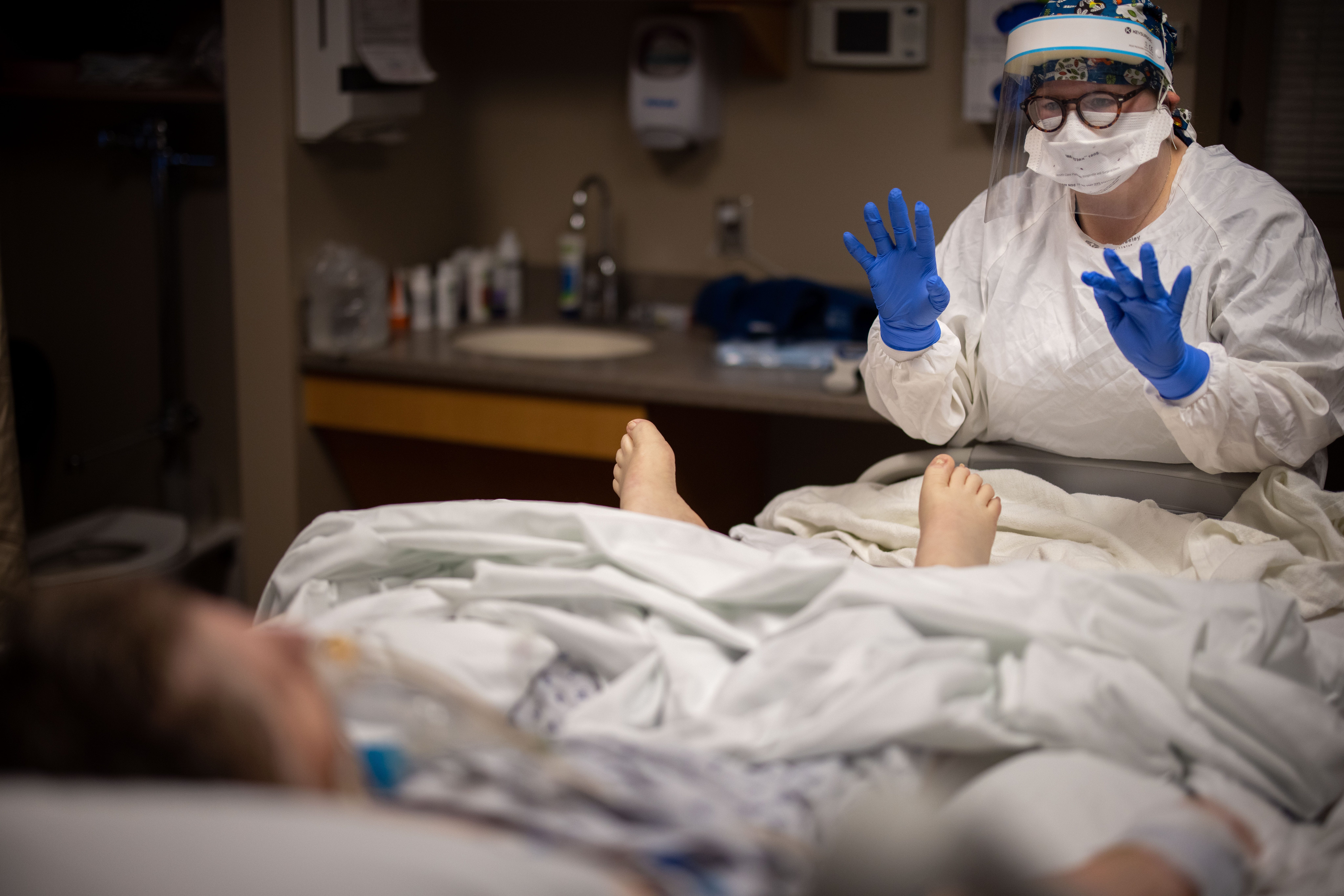 ICU nurse Abbey Malone asks a COVID-19 patient to wiggle her toes to assess her recovery before removing her breathing tube at Mary Greeley Medical Center in Ames, Iowa, Monday, Dec. 7, 2020.