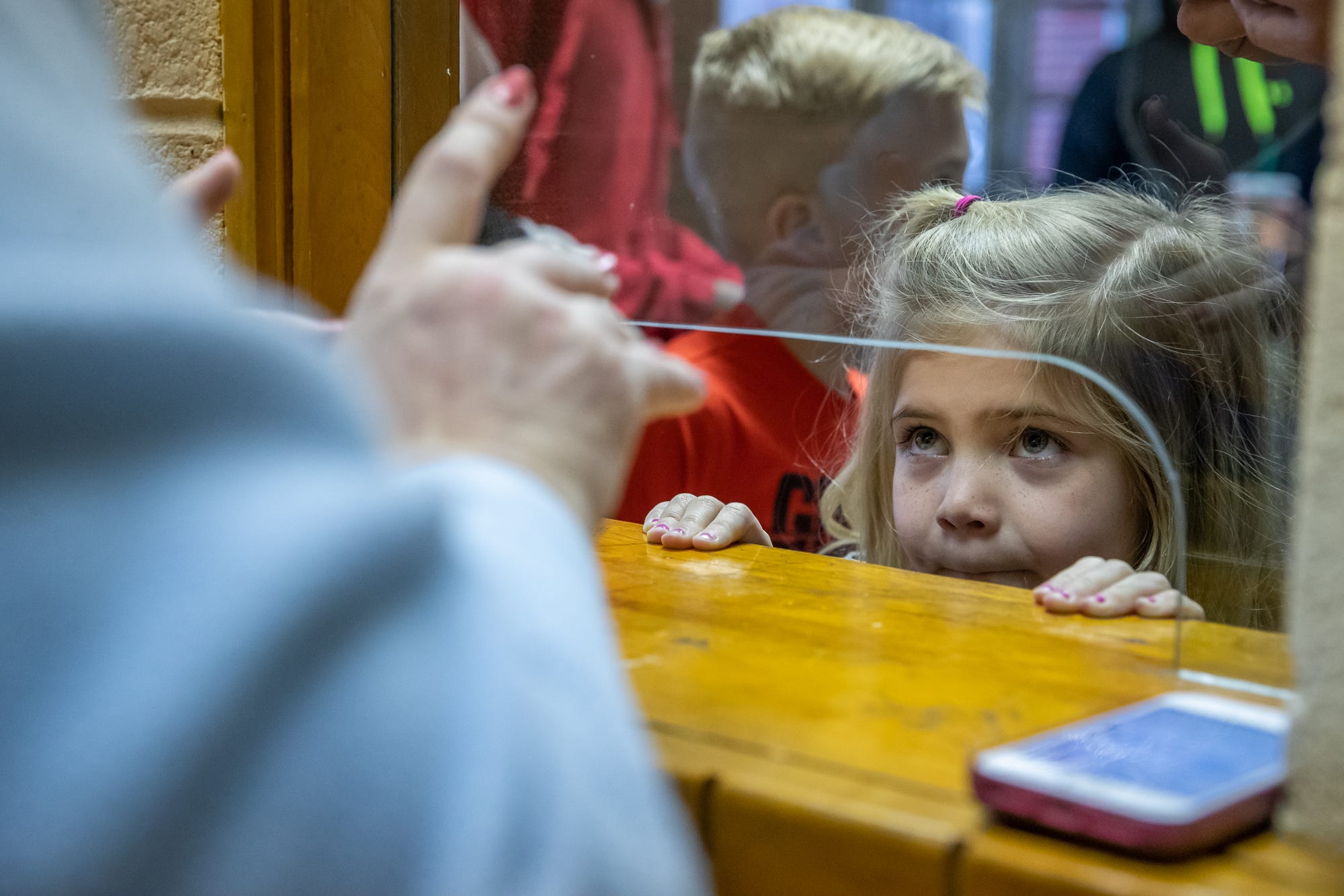 Serena Kesler, 6, of Warsaw, Ind., waits for her family's tickets before the start of a boys sectional tournament from the Elkhart North Side Gymnasium on Friday, March 6, 2020.