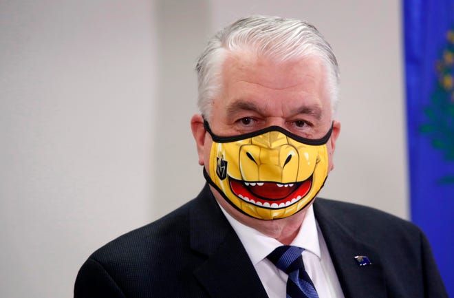 FILE - In this Sept. 29, 2020, file photo, Nevada Gov. Steve Sisolak speaks wearing a face mask themed after the Vegas Golden Knights' mascot Chance the Golden Gila Monster during a news conference in Las Vegas. Trick-or-treating has been canceled this year at the Nevada governor's mansion due to the coronavirus pandemic, and state health officials are advising people marking Halloween and El DÃ­a de los Muertos to avoid large gatherings. Sisolak said Wednesday, Oct. 14, 2020, the mansion will be decorated but the annual festivities will not take place to keep staff and visitors safe. (Steve Marcus/Las Vegas Sun via AP, Pool, File)