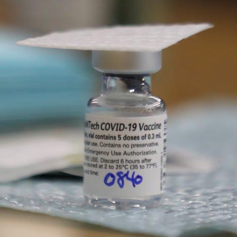A nurse placed an alcohol swab over an open vial o