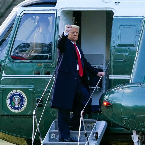 President Donald Trump gestures as he boards Marin