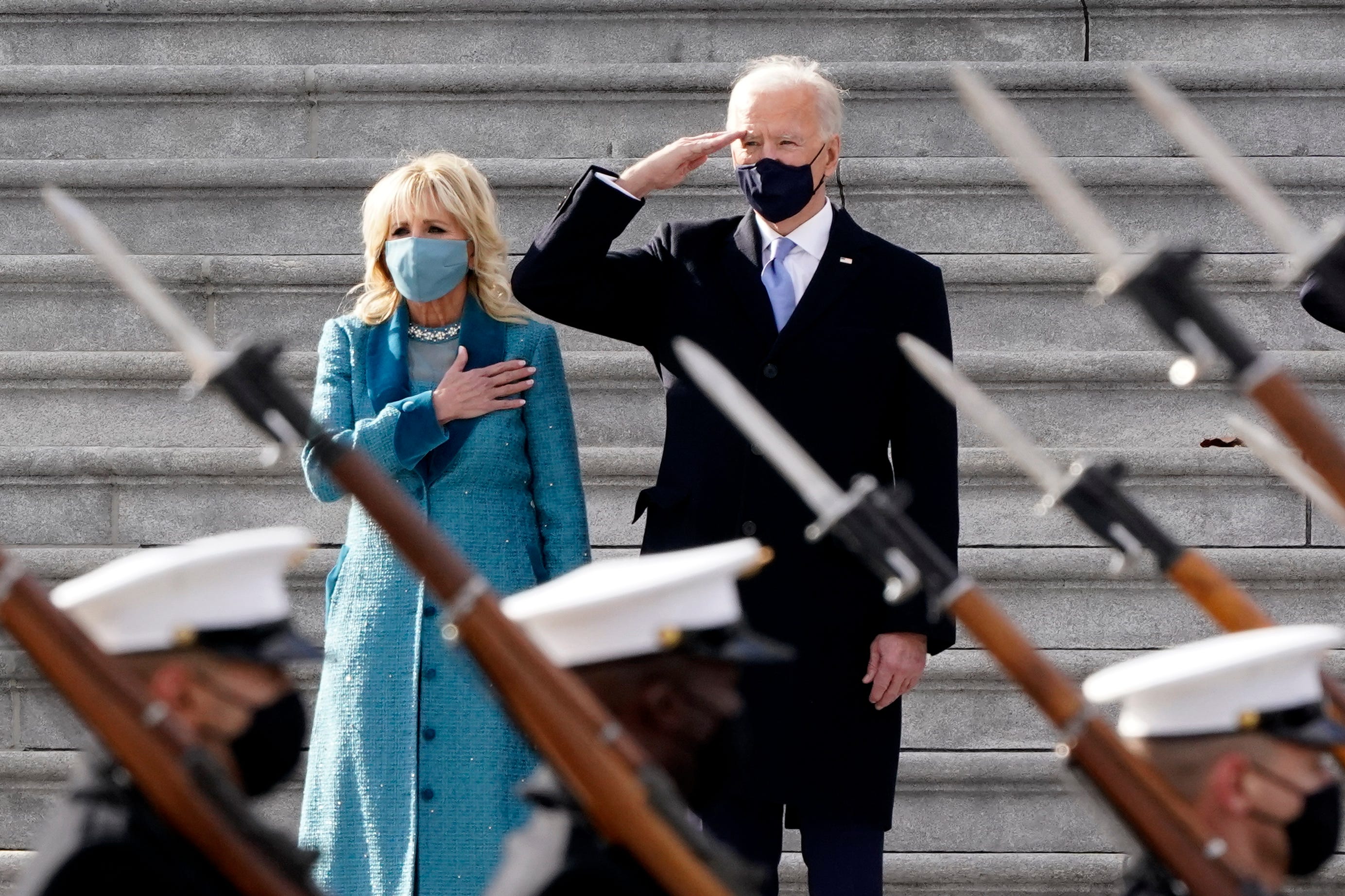 President Joe Biden and his wife Jill Biden watch a military pass in review ceremony on the East Front of the Capitol at the conclusion of the inauguration ceremonies, in Washington, Wednesday, Jan. 20, 2021.