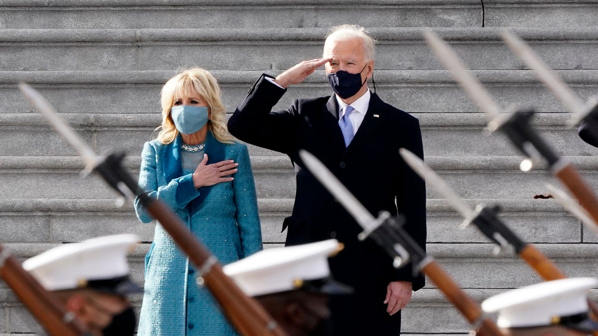 President Joe Biden and his wife Jill Biden watch a military pass in review ceremony on the East Front of the Capitol at the conclusion of the inauguration ceremonies, in Washington, Wednesday, Jan. 20, 2021.
