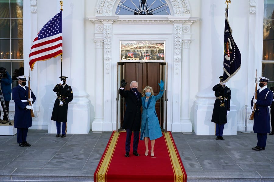 President Joe Biden and first lady Jill Biden wave as they arrive at the North Portico of the White House, Wednesday, Jan. 20, 2021, in Washington.