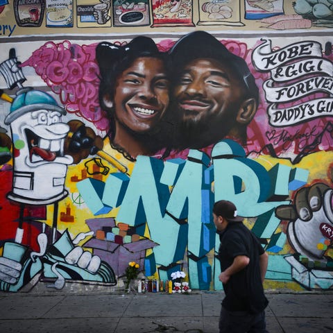 A man walks past a newly painted mural of Kobe Bry