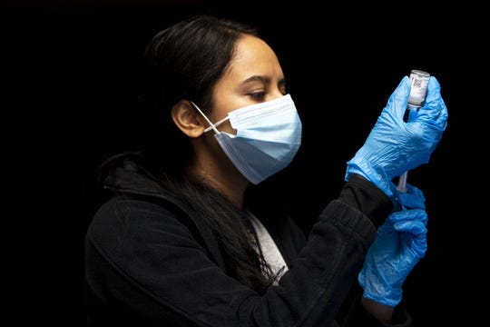 Miloni Patel, a public health nurse, prepares a COVID-19 vaccination at Hayden High School in Winkelman, Ariz. on Jan. 21, 2021.