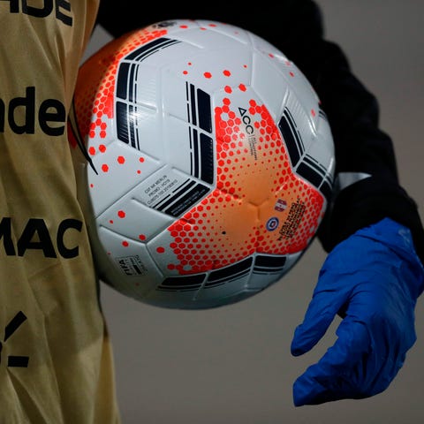 A ball boy wears gloves as a preventive measure ag