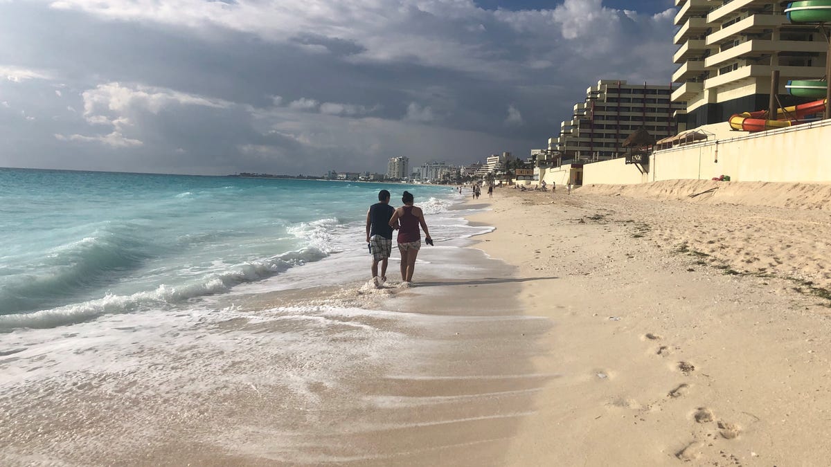 A couple strolls on the beach in the hotel zone in Cancun, Mexico